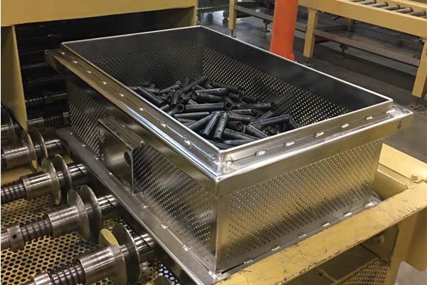 AUKE perforated cleaning basket showing open walls and freely loaded cylindrical parts