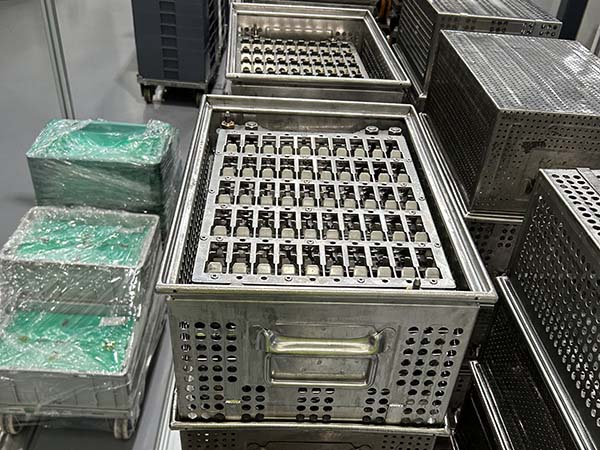 AUKE cleaning basket loaded with separated metal components before an industrial cleaning cycle